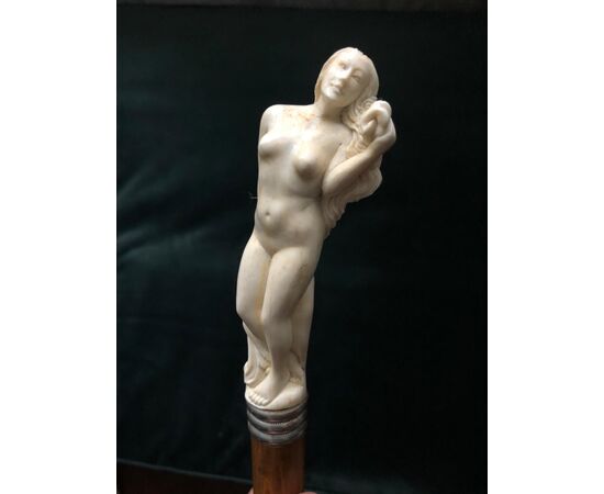Erotic stick with bone knob depicting a naked woman.     