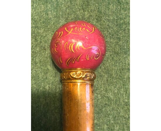 Stick with porcelain knob with stylized vegetable decorations. Low gold ring.     