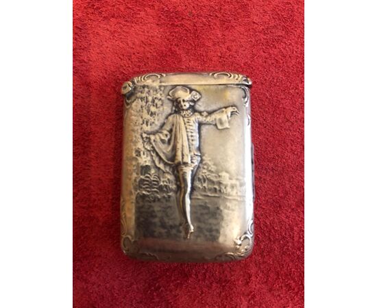Scatolina portafiammiferi in argento senza punzone con decoro a personaggio maschile e architetture.