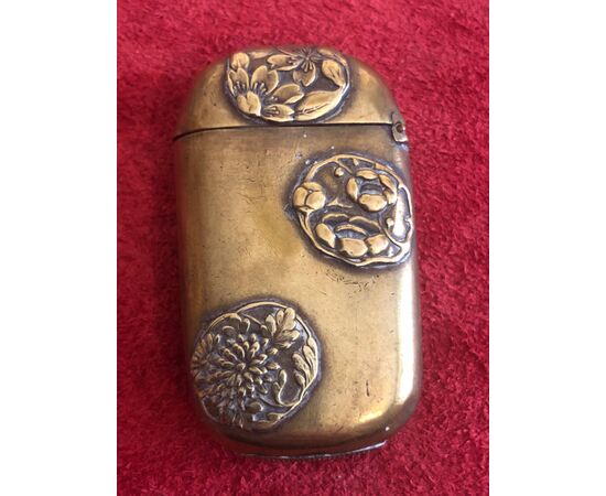 Brass matchbox with oriental floral motifs.     