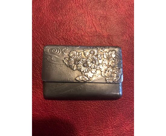 Scatolina portafiammiferi in metallo a forma di borsa-portafoglio con decori floreali art-nouveau.