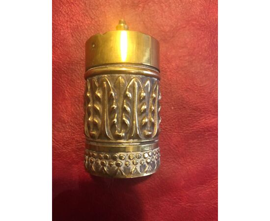 Cylindrical brass matchbox with stylized vegetable decorations.Vesta, England.     