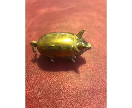 Pig-shaped brass matchbox.     