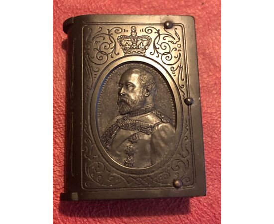 Scatolina portafiammiferi in bakelite a forma di libro con raffigurato profilo del Re Edoardo VII e iscrizione dell’ordine della giarrettiera.Inghilterra.