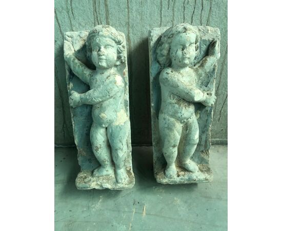 Pair of plaster sculptures depicting children.     