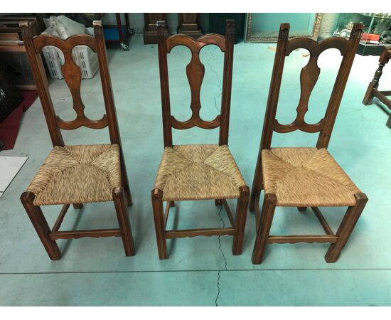 Three blond walnut chairs with straw covered seat.     