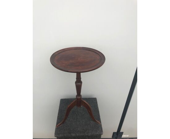 Round table in walnut with central leg and three feet.     