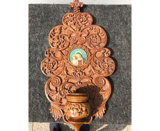Acquasantiera in legno scolpito con motivi vegetali stilizzati e miniatura  Madonna con Bambino.