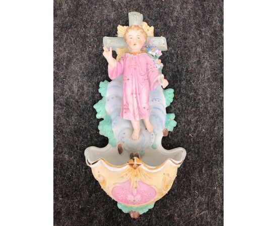 Acquasantiera in porcellana bisquit con figura di Gesù Bambino benedicente con mazzo di fiori.Germania.