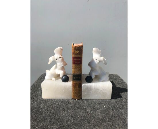 Pair of alabaster bookends depicting dogs with ball.     