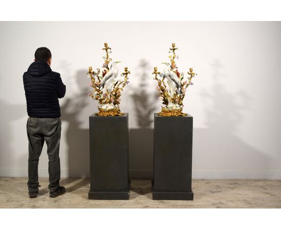  Coppia di grandi candelabri a tre luci in bronzo dorato con aironi e fiori in porcellana policroma, Francia, XIX secolo