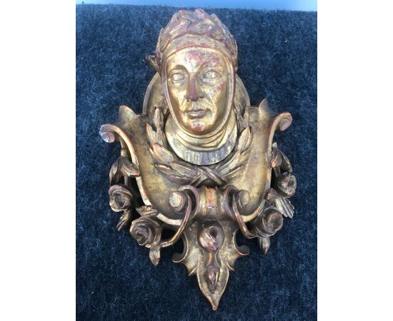 Carved and gilded wooden frieze with stylized plant motifs and central figure of Dante.     