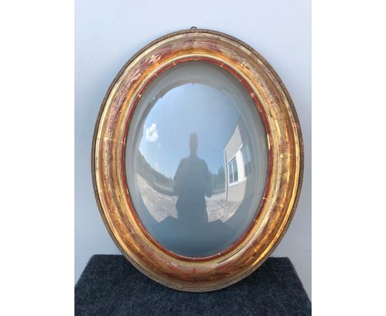 Frame in carved wood and gold leaf with floral motifs. Rounded glass.     