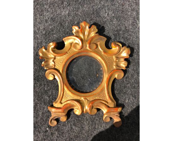Carved and gilded wooden frame with plant and rocaille motifs.     
