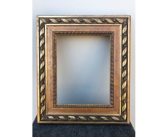 Carved and gilded wooden frame with tourchon motif.     