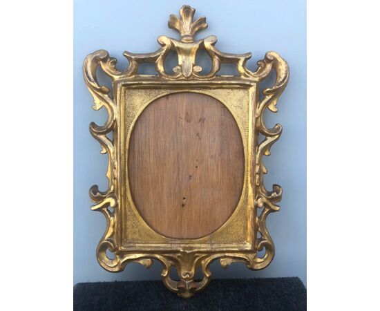 Carved, engraved and carved wooden frame with rocaille motifs.     