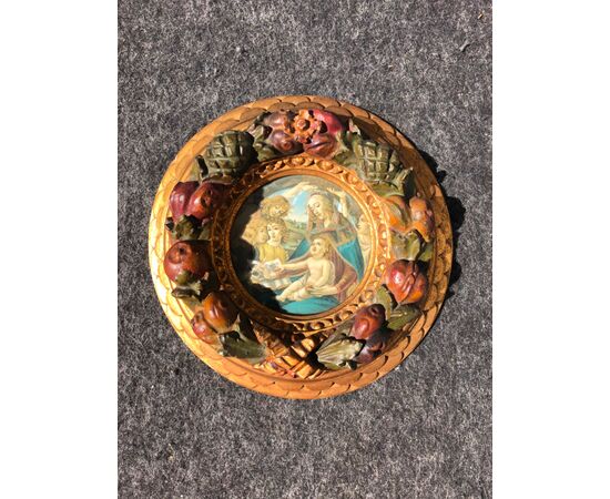 Round frame in carved, gilded and lacquered wood with embossed fruits and Madonna and Child print.     