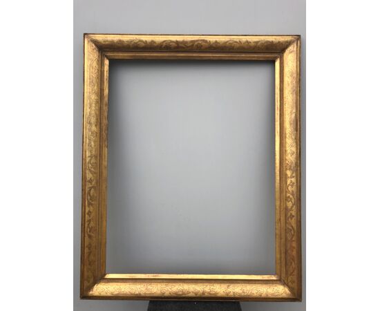 Large frame in carved wood and gold leaf with floral motifs.     