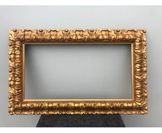 Carved and gilded wooden frame with leaf motif.     