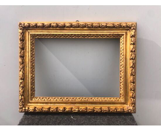 Carved wooden frame with bulbs and gold leaf.     
