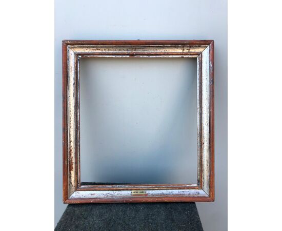 Frame in carved and silvered wood.     
