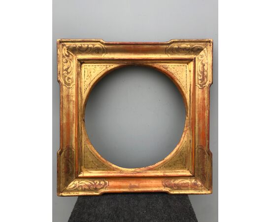 Frame in carved wood and gold leaf with plant decorations.     