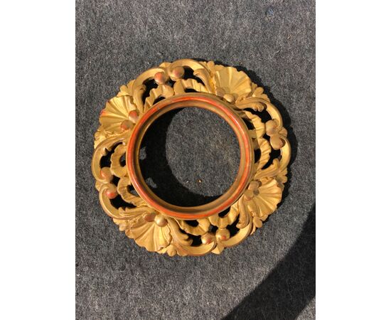 Round frame in carved and gilded wood with vegetable and shell motifs.     