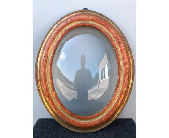Frame in carved wood and gold leaf with floral motifs. Rounded glass.     