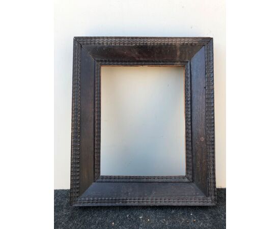 Frame in carved and ebonized wood.     
