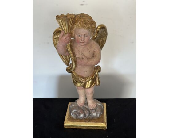 Angelo reggicornucopia in legno intagliato dorato. XVIII secolo.