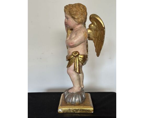 Angelo reggicornucopia in legno intagliato dorato. XVIII secolo.