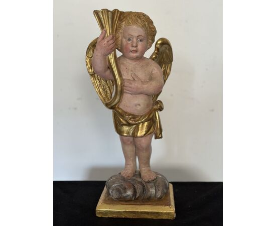 Angelo reggicornucopia in legno intagliato dorato. XVIII secolo.