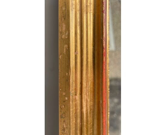 Grande specchiera in legno intagliato e dorato.