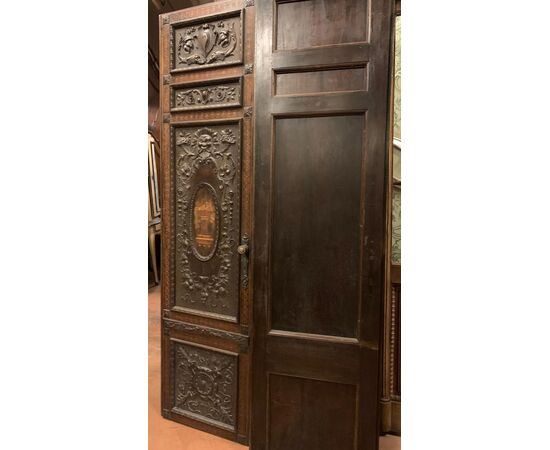 PTI754 - Porta in noce, due battenti scolpiti con mascheroni e decori fogliacei, epoca '800, misure cm L 106 x H 211