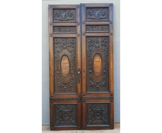 PTI754 - Porta in noce, due battenti scolpiti con mascheroni e decori fogliacei, epoca '800, misure cm L 106 x H 211