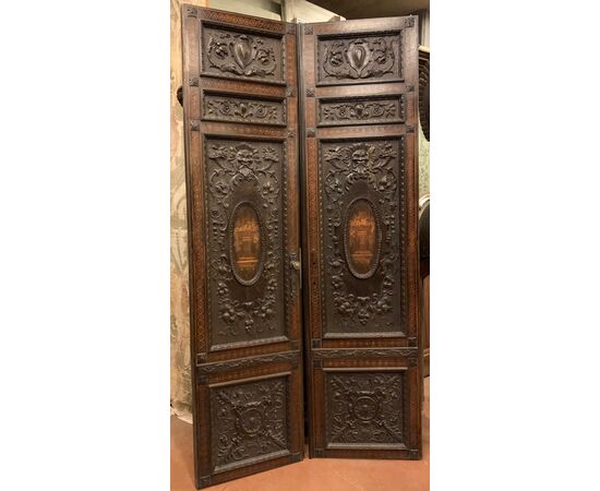 PTI754 - Porta in noce, due battenti scolpiti con mascheroni e decori fogliacei, epoca '800, misure cm L 106 x H 211