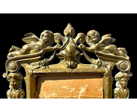 Cornice in bronzo con angeli,motivi neoclassici e arpie.