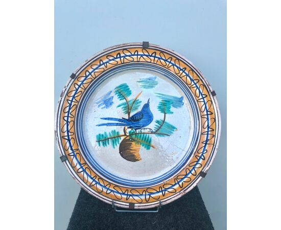 Majolica plate decorated with a bird in the cable and geometric motifs on the brim. Vietri manufacture     