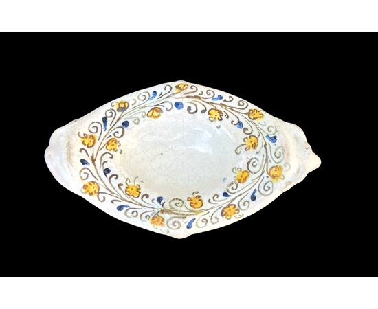 Saliera in maiolica compendiaria con decoro a racemi vegetali stilizzati.Faenza.