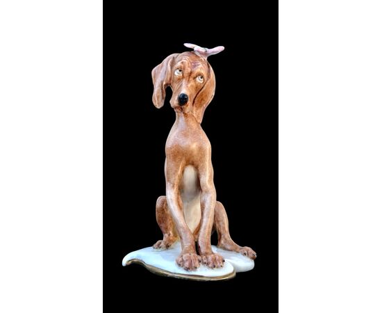 Figura di cane in porcellana con farfalla. Manifattura Cappe’.