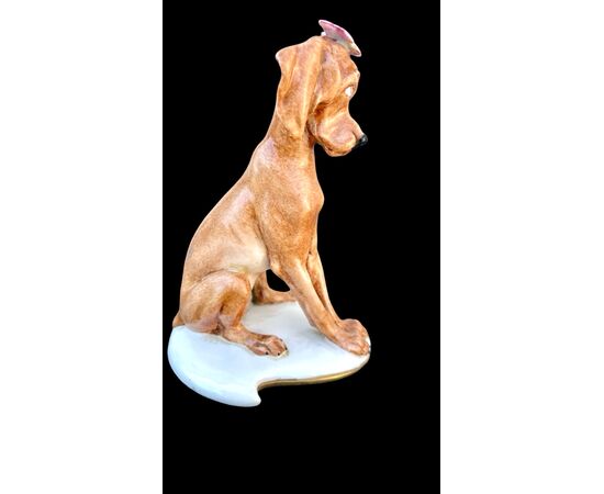 Figura di cane in porcellana con farfalla. Manifattura Cappe’.