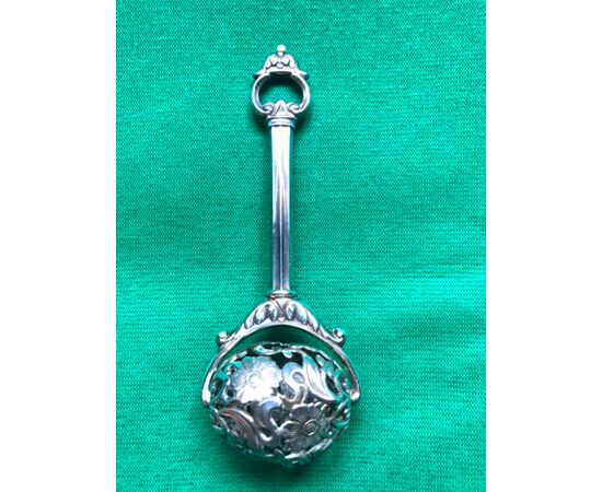 Baby rattle in embossed and perforated silver with stylized floral motifs.     