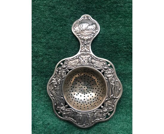 Silver tea strainer with pastoral and floral scenes. Holland.     