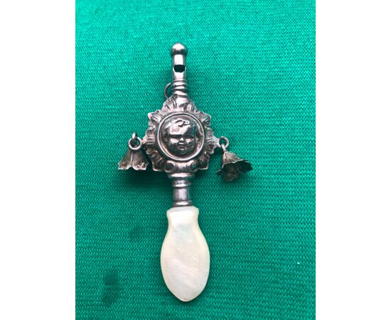 Baby rattle in silver with a child&#39;s face and mother-of-pearl handle.     