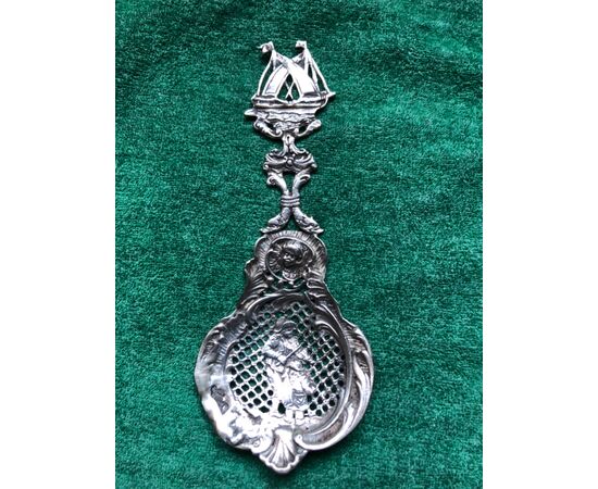 Spoon in perforated silver with rocaille motifs, musicians, putto and ship.     