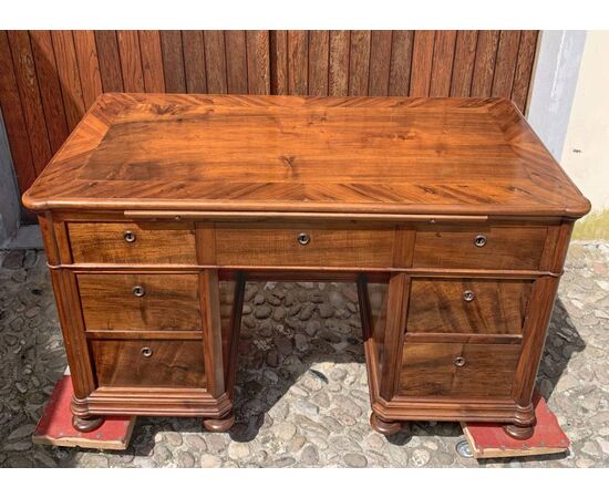 Scrivania a pancone lastronata in legno di noce. Italia, prima metà XIX secolo.