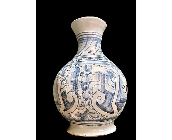 Bottiglia in maiolica a sfondo berettino con decoro a motivi vegetali e geometrici stilizzati.Faenza.