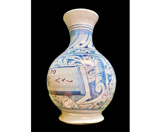 Bottiglia in maiolica a sfondo berettino con decoro a motivi vegetali e geometrici stilizzati.Faenza.