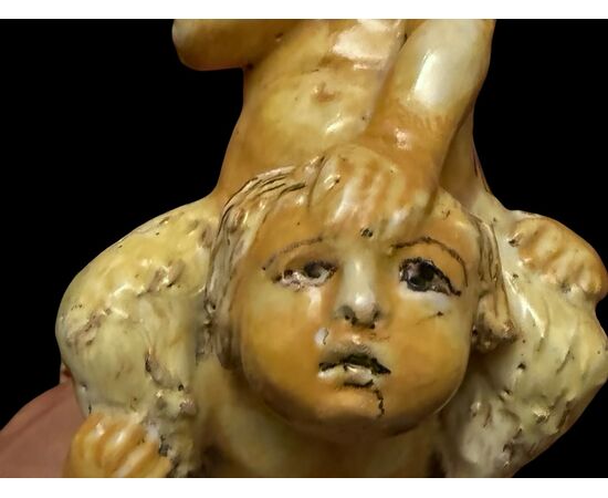 Scultura in maiolica policroma con due fanciulli che reggono un fauno.Nicola Giustiniani.Napoli.