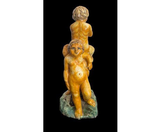 Scultura in maiolica policroma con due fanciulli che reggono un fauno.Nicola Giustiniani.Napoli.